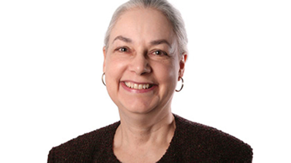 Head shot of Mary Malliaris wearing a black sweater on a white background